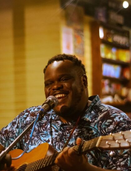 A Picture of George Kalukushi Smilling with his guitar